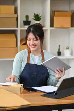 亚洲女人小业务老板确认订单采取订单客户数字平板电脑计算器