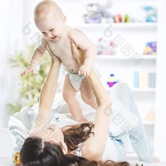 概念快乐家庭快乐妈妈。玩婴儿床上孩子的房间孩子的房间