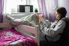 十几岁的女孩读取学校阅读坐着舒适窗口房间