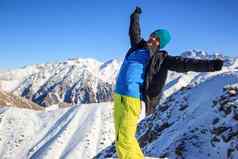 男人。站山峰提出了手天空雪山峰山哈萨克斯坦田山