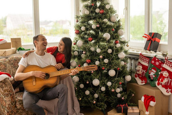 父亲女孩有趣的圣诞节假期爸爸戏剧吉他女儿休闲好爱的有爱心的爸爸婴儿快乐的有胡子的男人。执行歌曲