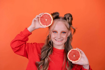 漂亮的<strong>渐变</strong>女孩橙色葡萄柚孤立的橙色背景热<strong>带</strong>柑橘类水果葡萄柚片橙色时尚的使少年肖像