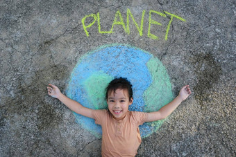 可爱的女孩说谎美丽的世界绘画粉笔标签地球沥青年轻的志愿者活动保存世界在户外概念世界环境一天和平一天