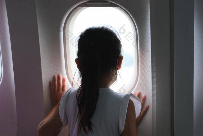 可爱的女孩旅行飞机孩子女孩空中视图天空云飞机窗口坐着飞机座位旅行概念