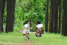 快乐孩子们玩绿色草春天花园姐妹运行草地夏天公园