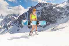 漂亮的年轻的模型滑雪比基尼滑雪面具站滑雪板雪山背景