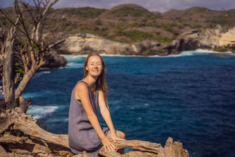 女人坐着树背景海天使的分流重镇penida巴厘岛印尼巴厘岛旅行概念