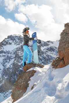 滑雪女人莫霍克他前岩石雪山