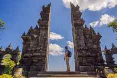 年轻的男人。旅游佛陀寺庙梵天维哈拉搜索班加尔巴厘岛印尼