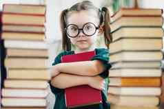 学前教育年龄女孩大轮眼镜持有红色的书书桩