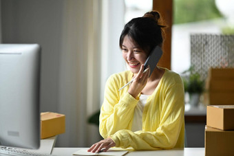微笑女小业务老板电脑会说话的移动电话<strong>确认订单</strong>客户在线销售电子商务概念