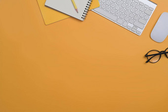 前视图无线键盘眼镜鼠标笔记本黄色的背景复制空间做广告文本