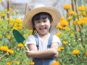 可爱的女孩他持有花园工具铲种植花花园孩子帮助妈妈花园园丁