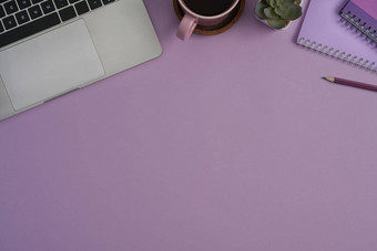 现代工作场所移动PC笔记本咖啡杯紫色的背景前视图平躺复制空间