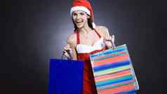 快乐年轻的女人穿着圣诞老人老人圣诞节商店