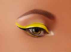 特写镜头女眼睛明亮的黄色的眼线笔化妆霓虹灯迪斯科化妆时尚修指甲夏天美风格