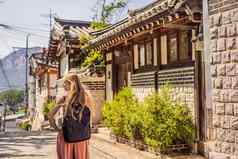 年轻的女人旅游北村韩屋村著名的的地方朝鲜文传统的房子保存旅行韩国概念