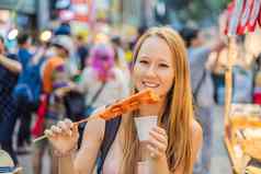 年轻的女人旅游吃典型的朝鲜文街食物走街首尔辣的快食物简单的发现当地的朝鲜文殉道灵魂韩国