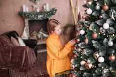 可爱的青少年女孩装修圣诞节树生活房间