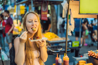 年轻的女人旅游吃典型的朝鲜文<strong>街</strong>食物走<strong>街</strong>首尔辣的快食物简单的发现当地的朝鲜文殉道灵魂<strong>韩国</strong>