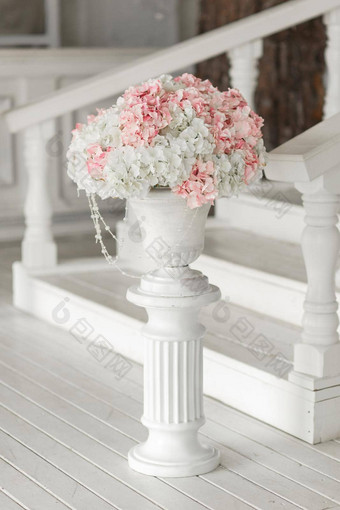 美丽的精致的花束花白色轮盒子站瓷砖人行道上