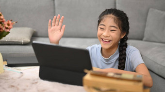 快乐亚洲女孩看学习在线虚拟教室电脑移动PC电子学习教育概念