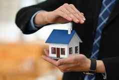 男人。手庇护房子模型概念真正的房地产投资者租赁保险购买销售合同维护