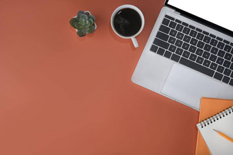移动PC电脑笔记本咖啡杯橙色背景时尚的工作场所前视图
