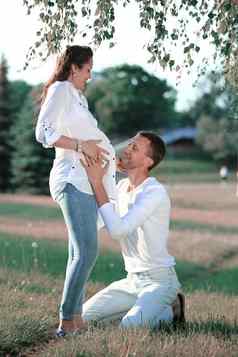 快乐丈夫拥抱怀孕了妻子走公园