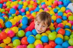 快乐孩子男孩玩色彩斑斓的塑料球操场上高视图可爱的孩子有趣的在室内