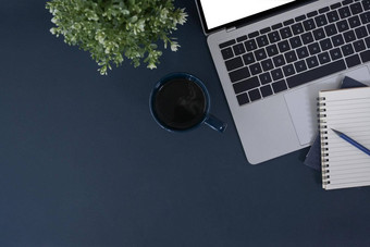 时尚的工作空间移动PC电脑笔记本咖啡杯黑暗蓝色的背景前视图平躺