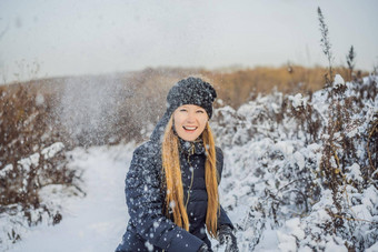 冬天女孩扔雪球相机微笑快乐有趣的在<strong>户外下</strong>雪冬天一天玩雪可爱的好玩的年轻的女人<strong>户外</strong>享受雪