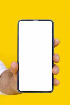 关闭男人。手持有智能手机白色空白屏幕蓝色的电话情况下孤立的黄色的背景移动电话无框架设计概念移动应用程序广告复制空间