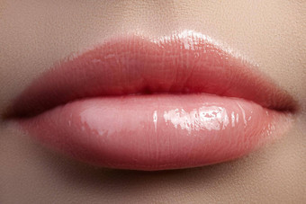 特写镜头美丽的女嘴唇明亮的唇彩化妆完美的清洁皮肤光新鲜的唇化妆