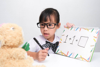 可爱的亚洲女孩玩老师<strong>角色游戏</strong>女孩教学数学泰迪熊朋友自主学习孩子们的玩学习