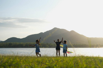 孩子们飞行风筝运行草地湖<strong>日</strong>落妈妈。健康的夏天<strong>活动</strong>孩子们有趣的时间<strong>家庭</strong>