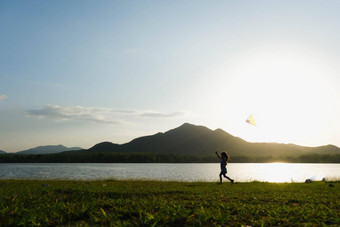 孩子玩风筝运行草地湖<strong>日</strong>落健康的夏天<strong>活动</strong>孩子们有趣的时间<strong>家庭</strong>