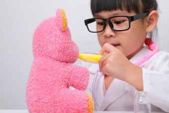 可爱的亚洲女孩玩医生角色游戏给注射生病的泰迪熊朋友自主<strong>学习</strong>孩子们的玩<strong>学习</strong>