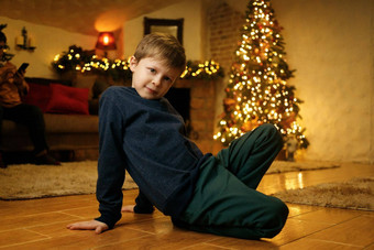 男孩坐在地板上节日房间夏娃圣诞节假期