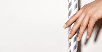 手明亮的黄色的法国修指甲指甲艺术设计特写镜头手时尚的霓虹灯指甲条纹打印
