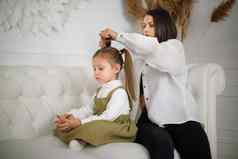 集中妈妈收集女儿头发坐着沙发上奢侈品白色室内