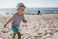 可爱的孩子男孩有趣的孤独的海洋海滩孩子玩运行阳光好天气一天