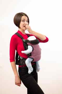 婴儿袋困惑年轻的妈妈。婴儿人体工程学航空公司孤立的白色