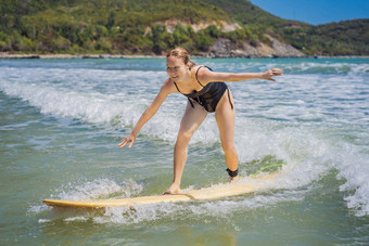 美丽的年轻的女人骑波运动冲浪者女人冲浪背景蓝色的天空云透明的波户外活跃的
