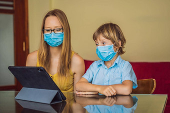 男孩研究在线首页平板电脑妈妈帮助学习妈妈儿子医疗面具保护coronovirus研究检<strong>疫全球</strong>流感大流行科维德病毒