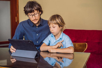 男孩研究在线首页平板电脑父亲帮助学习研究检疫全球流感大流行科维德病毒