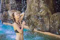年轻的快乐的女人水流池一天水疗中心热弹簧
