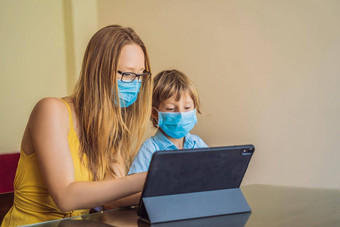 男孩研究在线首页平板电脑妈妈帮助学习妈妈儿子医疗面具保护coronovirus研究检<strong>疫全球</strong>流感大流行科维德病毒