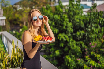 年轻的女人休息阳台板水果生活得平衡放松健康的质量生活生活方式夏天假期假期自由职业者女人容易休息度假胜地酒店阳台和平心