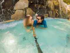 快乐家庭度蜜月假期结婚了爱的夫妇游泳有趣的瀑布池活跃的生活方式人户外旅行活动夏天假期热带岛